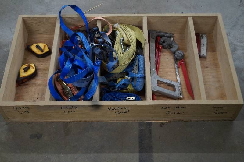 Wood shelf, chalk lines, ratchet straps, hacksaw, and knives