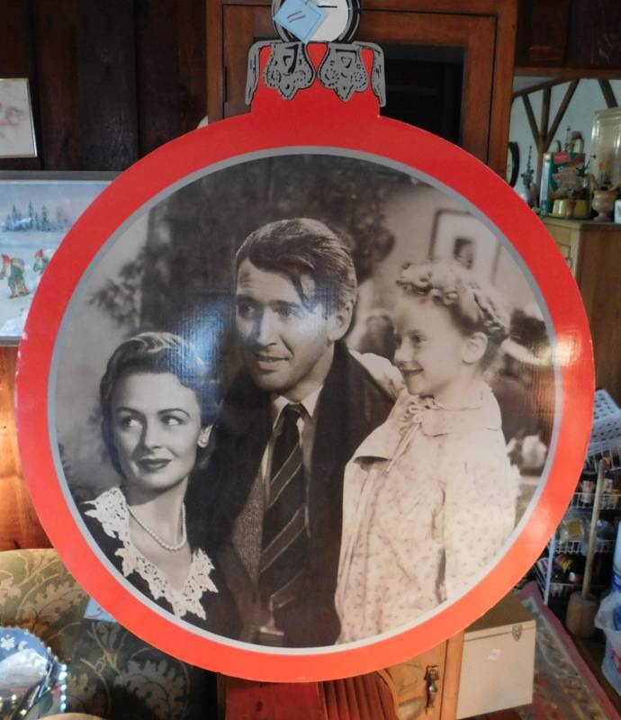 lot 11 image: large round cardboard two sided ornament from Its a wonderful life