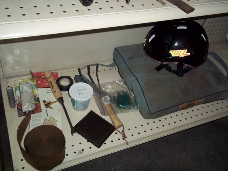 Shelf lot with Garden weeder, bike helmet, boat cushin, and wallet