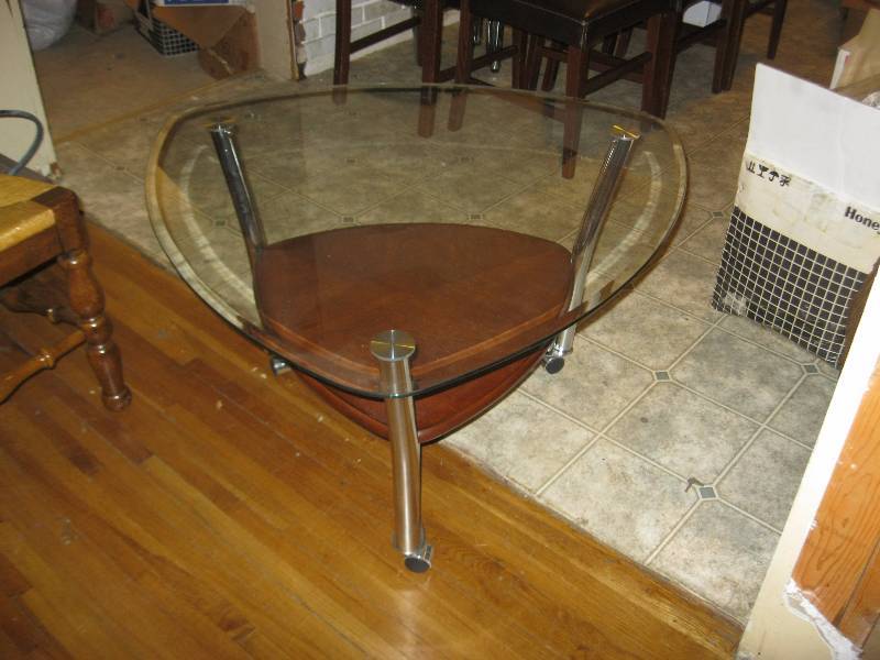 lot 8 image: Glass And Wood Coffee Table On Wheels. 20.5H x 36W