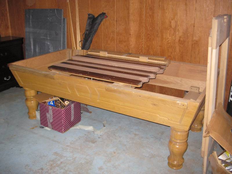 lot 27 image: 7.5 Foot Pool Table. 3 Piece Slate. Leather Pockets. Comes With All Accessories Including Balls And Cues. Has Some Wear. Needs Felt And Needs To Be Reassembled