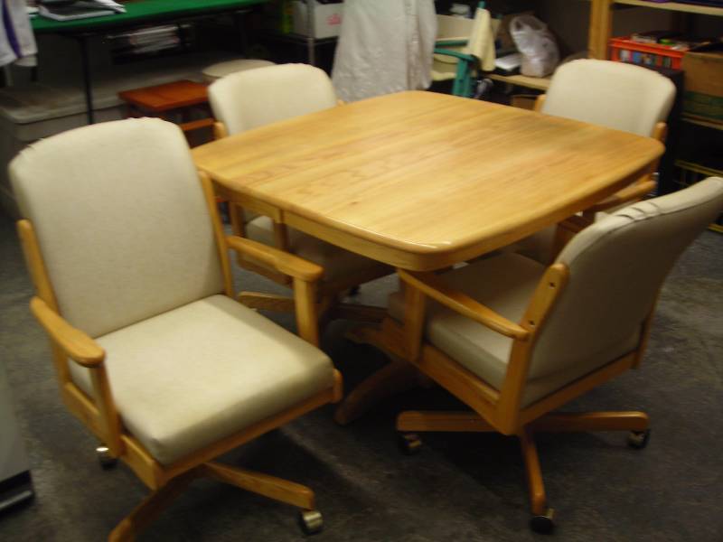 lot 42 image: Whitaker Brand Dinette Set 42 x 42 With 18 Inch Leaf & 4 Chairs On Wheels Oak