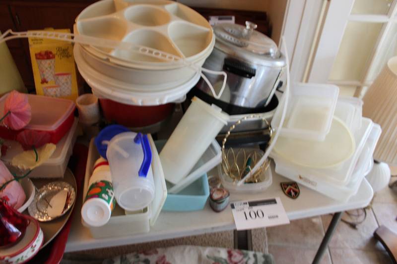 lot 100 image: Table Lot includes various tupperware pieces and numerous kitchen wares.  Does NOT include the table.