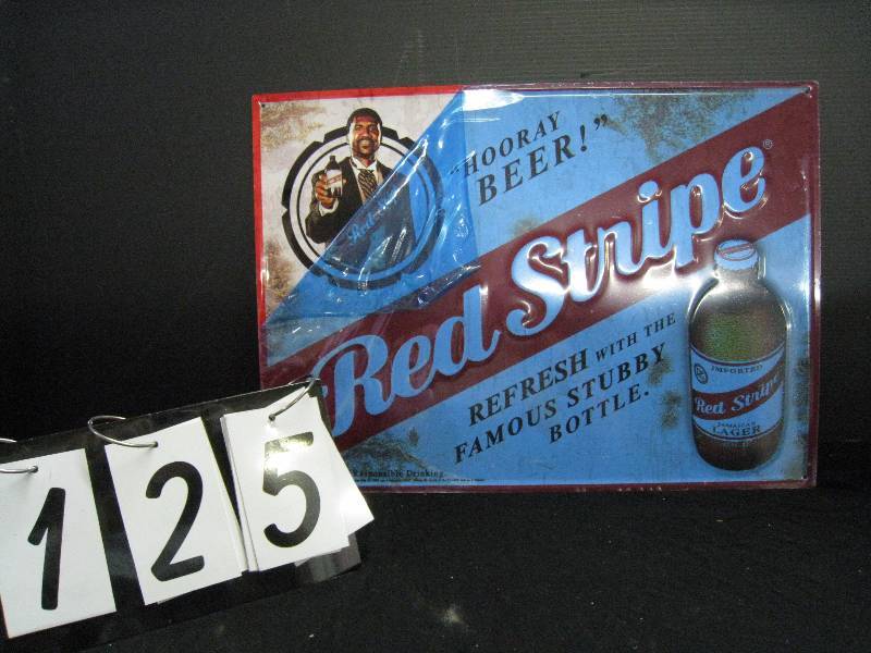 lot 125 image: Red Stripe Beer embossed metal sign NOS, blue protective film still intact except where pulled back to show actual color