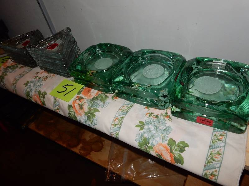 lot 51 image: 6, 7in x 7 in Green heavy glass candle holders.  20, 4in triangular candle holders.. All new