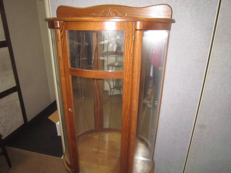 LIGHTED OAK CURVED FRONT CURIO WITH GLASS SHELVES.