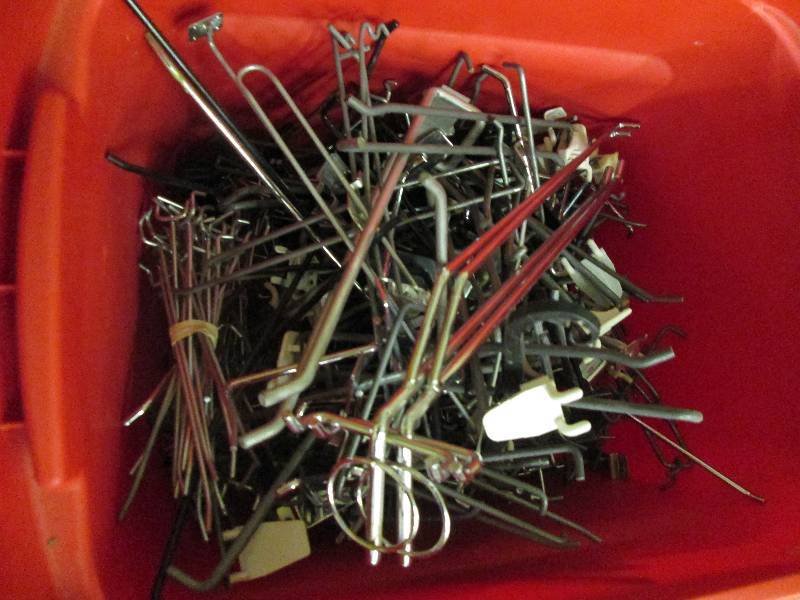 Red tub of assorted size peg hooks...