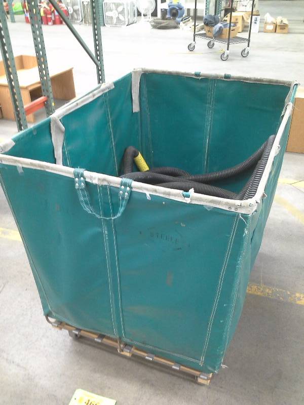 Green shipping and receiving bin filled with submersible sump pumps and hose