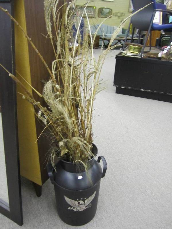 Milk can with peacock feather and g...