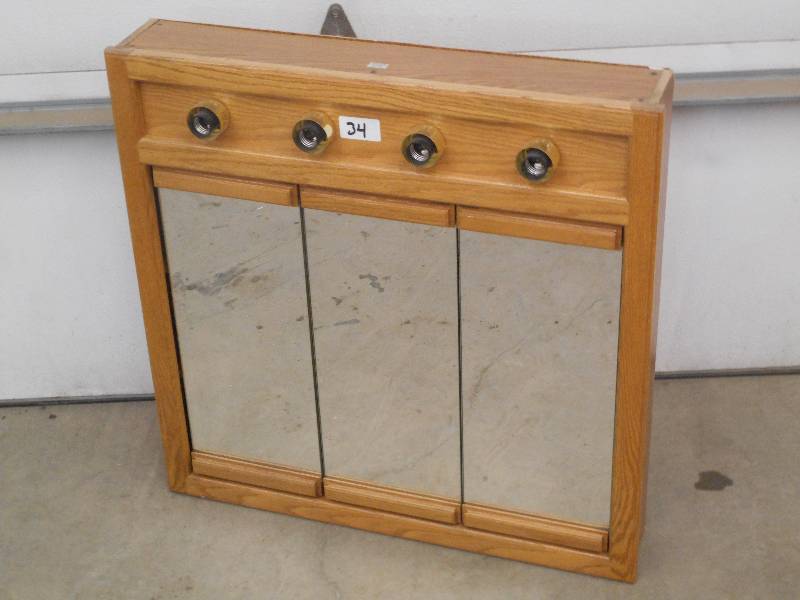 lot 34 image: Lighted 4-Bulb Mirrored Vanity Cabi...