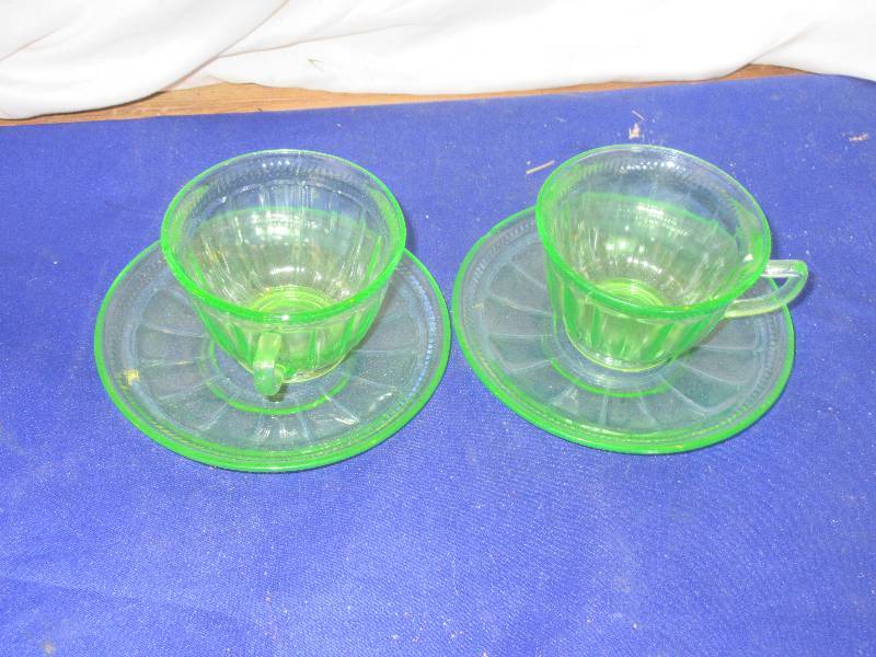 2 green depresion glass cups and saucers