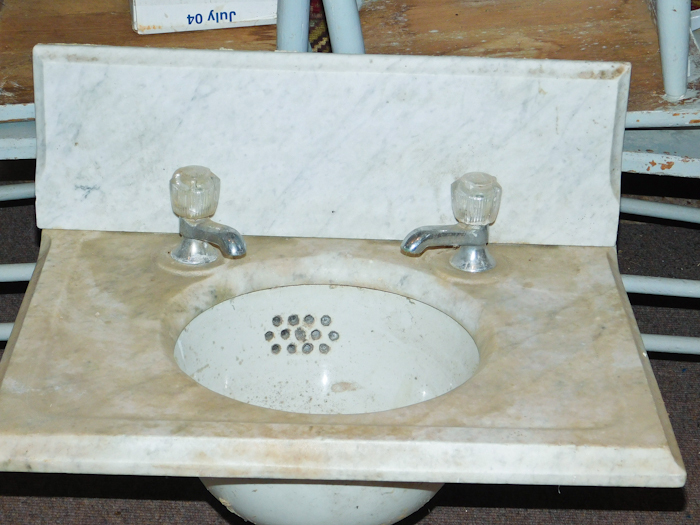 lot 92 image: porcelain sink with marble surround and backsplash with vintage faucets
