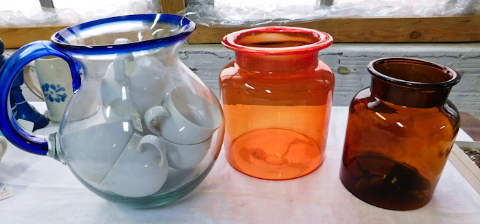 lot 57 image: Large clear pitcher with blue rim handle two glass orange containers
