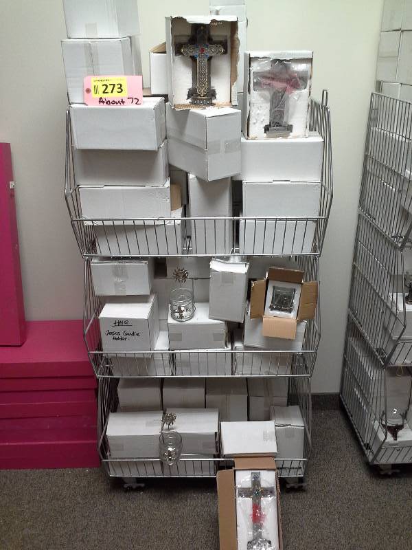 Three shelves full of various pewter candleholders, figurines, religious artifacts