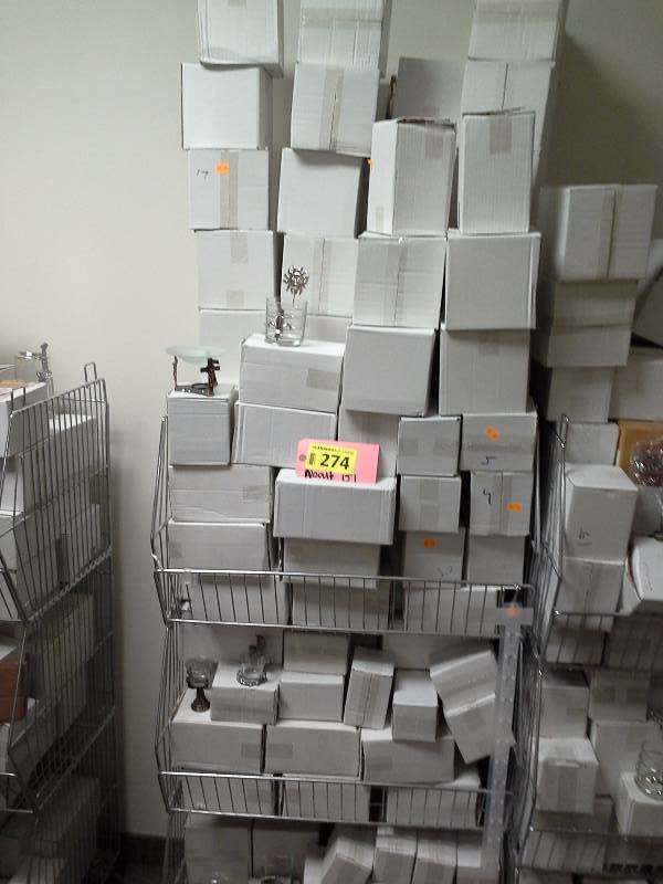 Three shelves full of various pewter candleholders