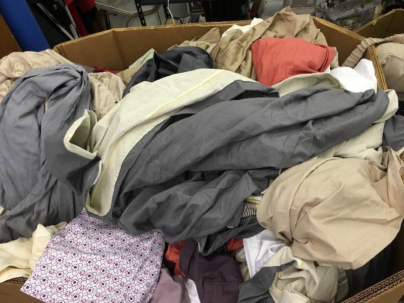 lot 156 image: Large gaylord of new sheets,couch covers and curtains random sizes and colors