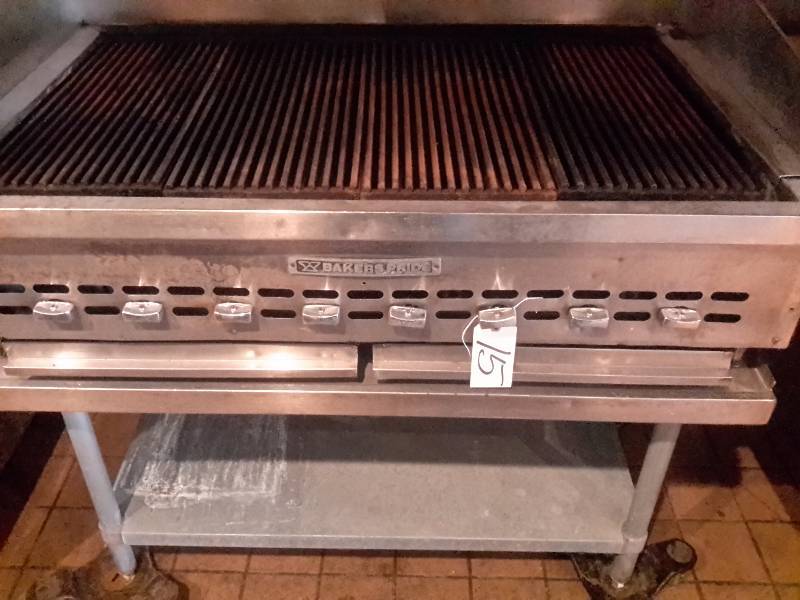 lot 15 image: Gas Char Broil Grill.. Bakers Pride.. 48 in x 30 in.. On Stainless steel table with rollers.