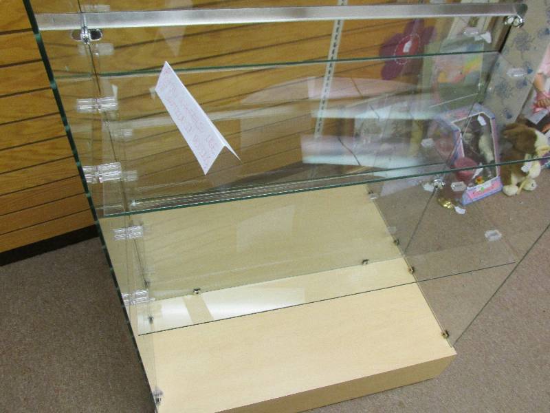 Nice clean glass compartmentalized display fixture on sturdy wheeled base for easy movement.  This measures 30 wide, and 2 feet deep, 1 foot display shelf on each side.  Add value to your inventory or collection by showcasing it in this beautiful case